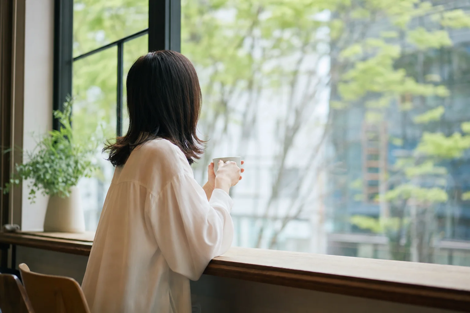 送迎を終えた後、一人でカフェで一息ついている女性のイメージ写真