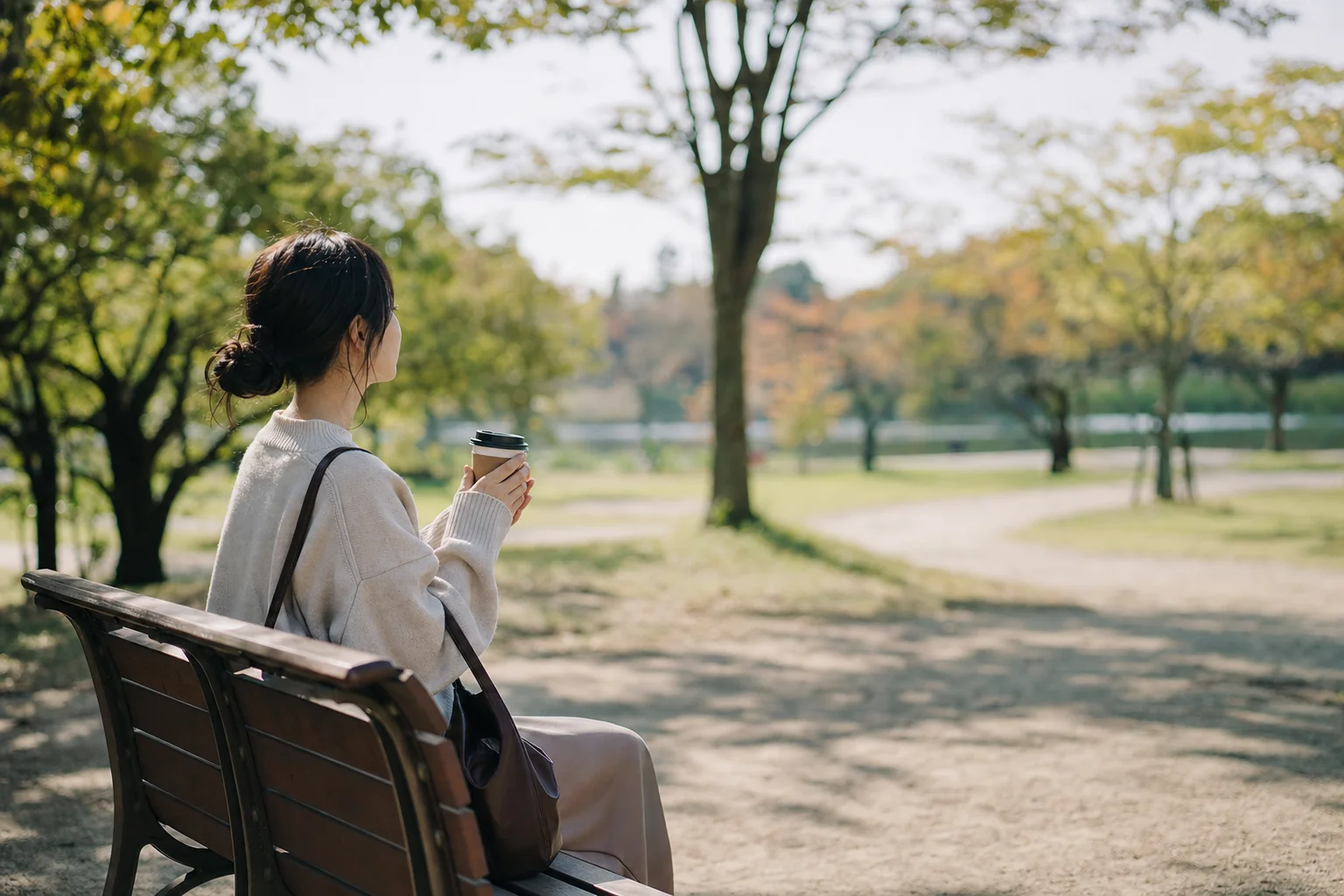 家族と少し距離を置いて、自分の時間を静かに過ごしている女性のイメージ写真